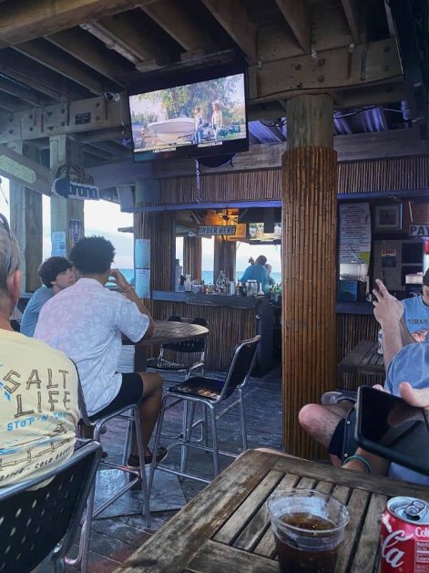 The tables and TVs inside the beach bar in Destin, Florida that is right along the ocean.