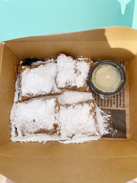 The delicious beignets topped with powdered sugar and buttercream dipping sauce on the side. from Beignets & Brews located on the Destin Harbor Boardwalk.