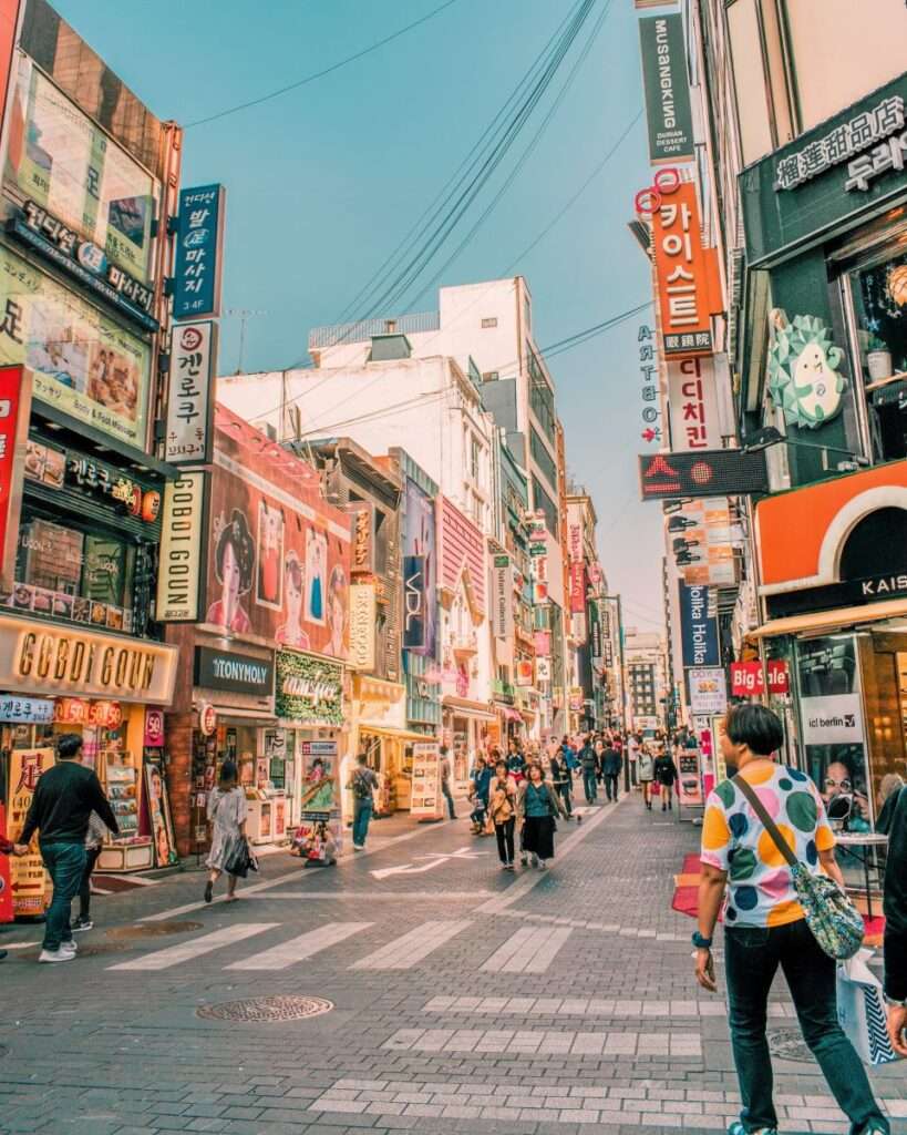Walking along downtown South Korea during the day bustling with people and cool shops.