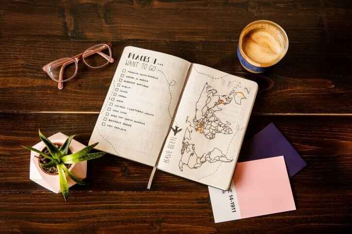 Journal pages showing a travel bucket list and world map which is one of the fun things to do on long flights.