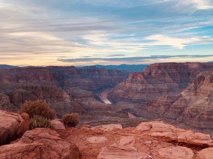 The views from above looking down below at the Grand Canyon with the winding river and red sock and sand.