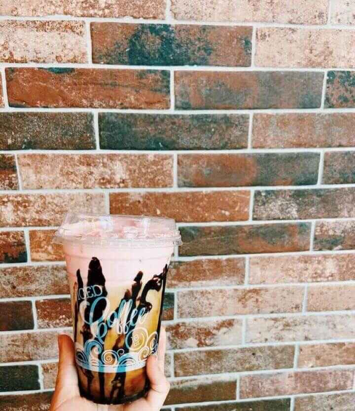 The layered Neapolitan summer seasonal drink from Java House Coffee shop in Indianapolis pictured in front of a red brick wall.