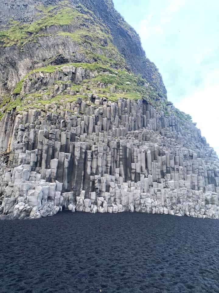 The contrast of the black sand and grey basalt columns at Reynisfjara Beach in the town of Vik in Iceland.