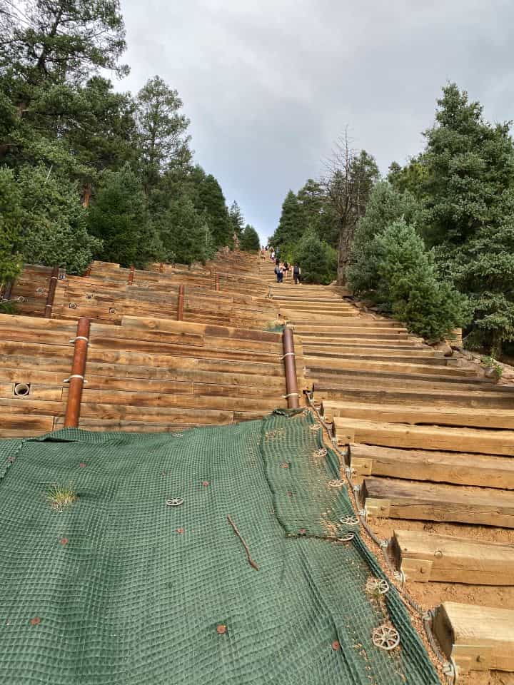 The steep wooden stairs of the Manitou Incline with the view of the lush green trees on either side.