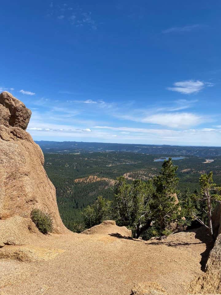 The view from the summit of Crag's Peak overlooking blue lakes, mountain ranges, and beautiful pine trees.