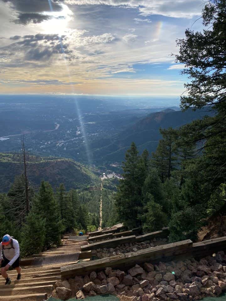 The view of the sunrise shining while climbing the Manitou Incline while taking a break at one of the stand-off areas to the side.