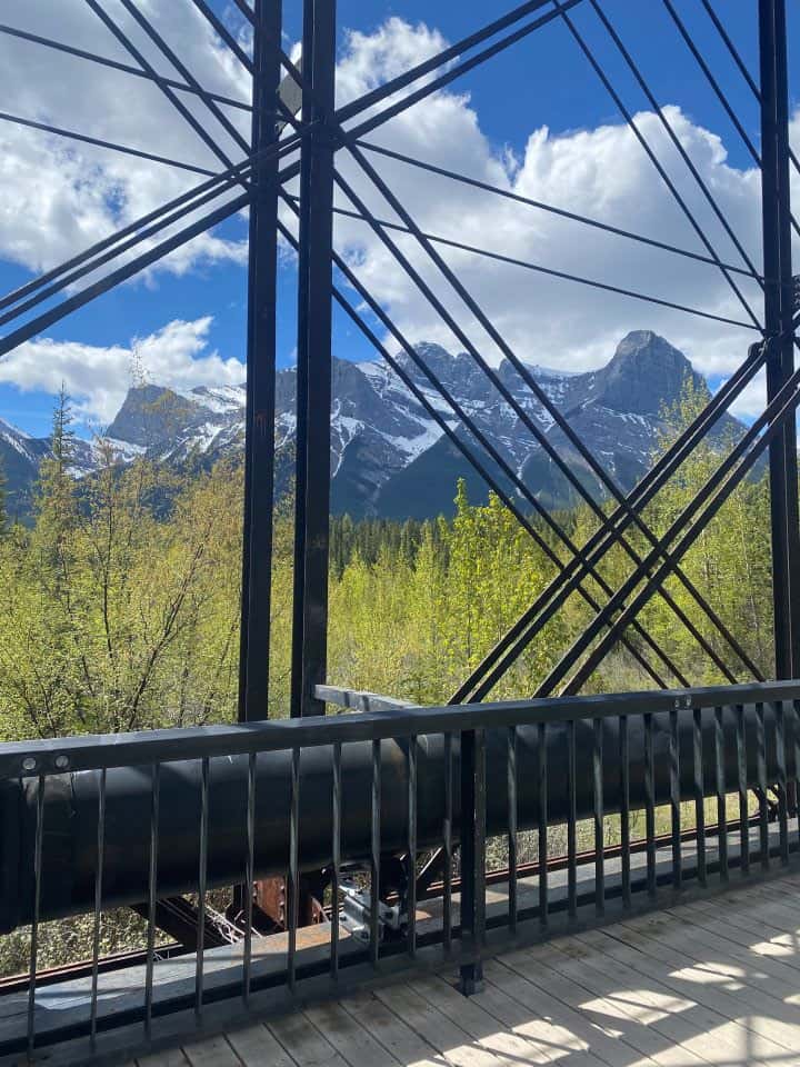 The view of the ginormous Canadian Rockies mountains you can see from the iconic Canmore Engine Bridge as you are walking around during your one day in Canmore.