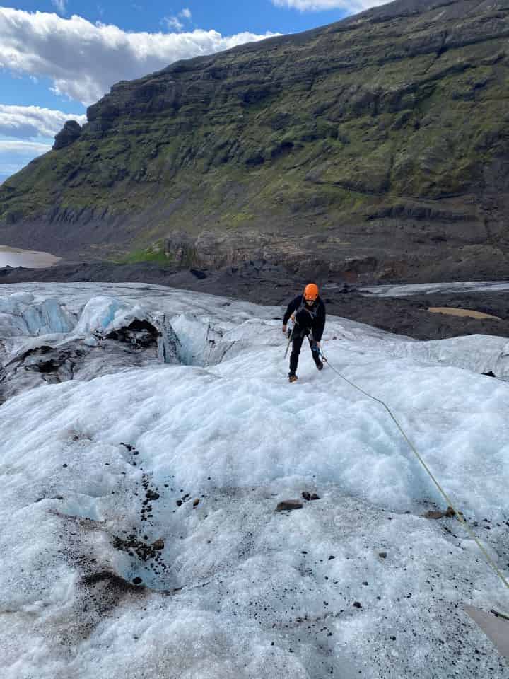 A person doing a glacier hike on Vatnajokull Glacier in Iceland with crampons and a rope to stay tethered on during the hike.