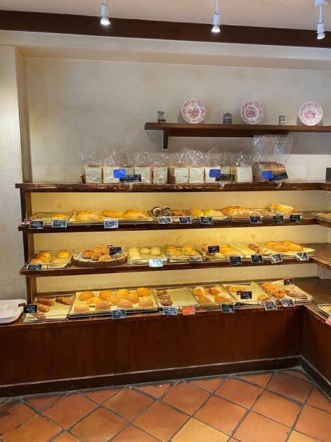 The inside of Boulangerie Friandise Karasuma bakery in Kyoto with its wide range of baked goods ranging from donuts to melon pans and fresh baked sandwich bread.