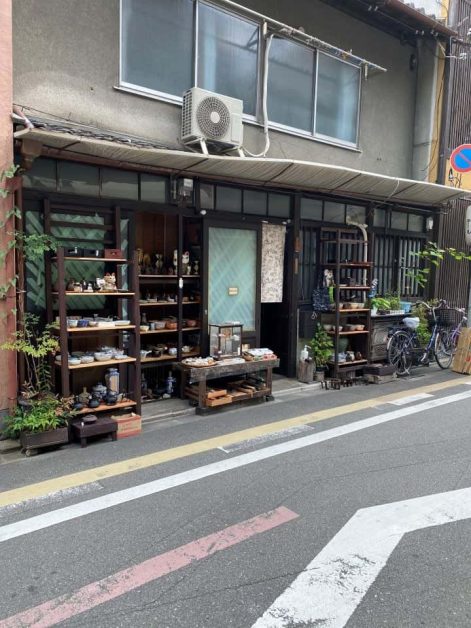 A small shop located along a back street in Kyoto selling various plants, pottery, and home goods.