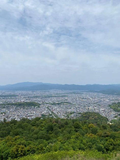 The view of the city of Kyoto and mountains in the distance at the summit of Mount Daimonji hike in Kyoto near Nanzen-ji Temple.