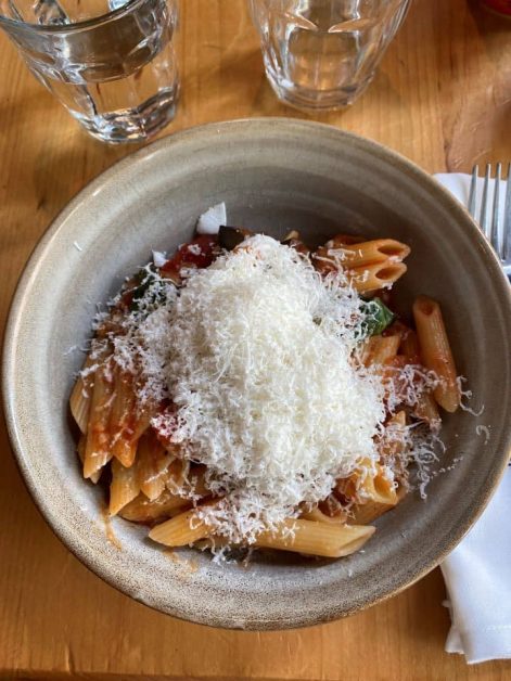 The delicious pasta alla norma dish at Trattoria Mercatto which consists of penne noodles, eggplant, tomatoes, and fresh shaved cheese on top.
