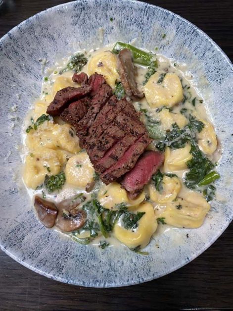 The Truffle + Steak Tortellini dish served at Earl's Kitchen + Bar restaurant in Toronto with its creamy truffle sauce and perfectly cooked medium rare sirloin on top.