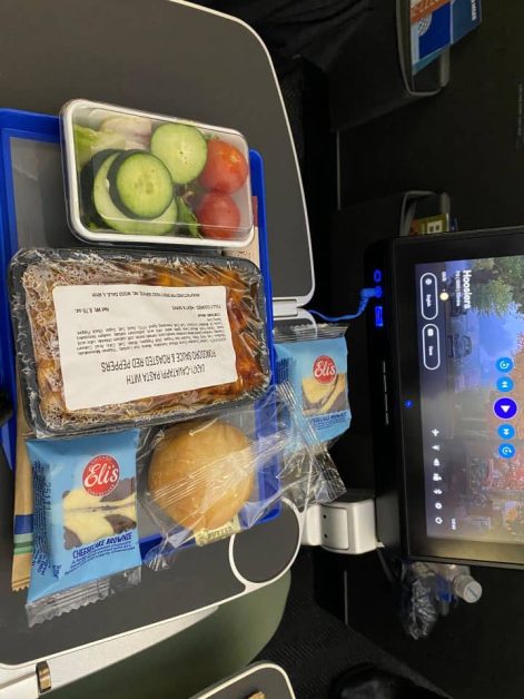 The dinner served on the United Airlines flight in Economy from San Francisco to Haneda Airport in Tokyo which includes fresh vegetables, pasta, a cheesecake brownie, and a dinner roll.