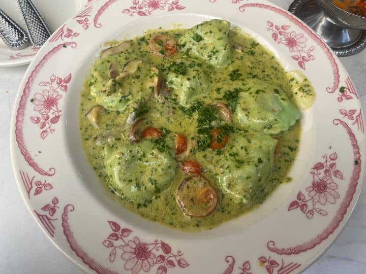 The delicious creamy spinach and pesto sauce on top of tortellini pasta and mushrooms served at Carbonara restaurant in Arlington VA.