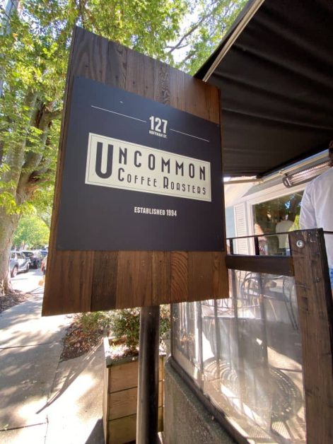 The dark wood and black sign outside of Uncommon Coffee Roasters coffee shop in Saugatuck.