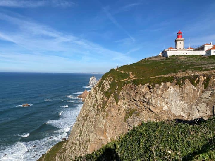 A lighthouse on a cliff at Cabo da Roca, overlooking the ocean, marking the westernmost point in Europe.