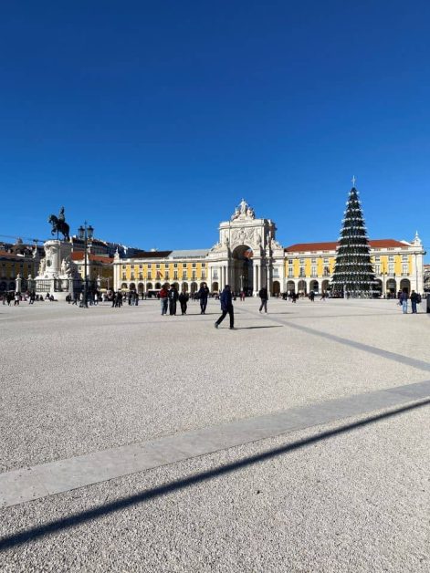 The Praca do Comercio in Lisbon on a sunny day in early December decorated for Christmas with a large tree.
