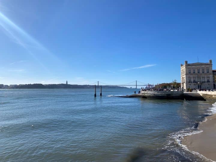 The view of the tagus river from Praca da Comercio in Lisbon with the iconic bridge in the background.