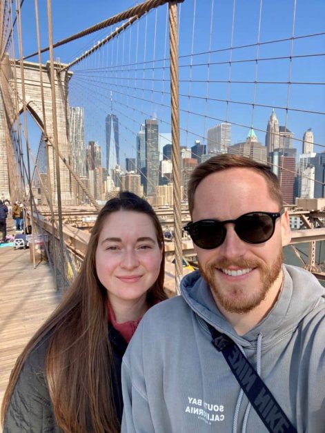 My husband and I on the Brooklyn Bridge in NYC with the Manhattan skyline behind us.