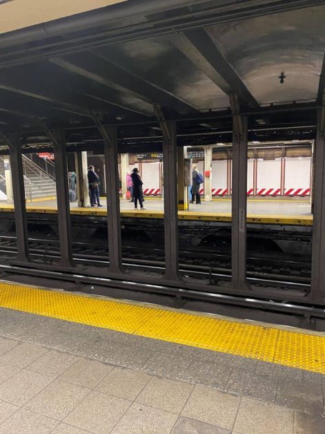 The train station at New York City where commuters are walking along the platform.