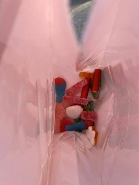 A variety of swedish candies inside a pink paper bag, viewed from above. The candies are colorful and different shapes from Bon Bon in New York City.