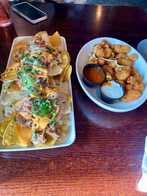 Loaded pulled pork nachos and a side of cheese curds served at Lake City Social in Lake Geneva, Wisconsin.